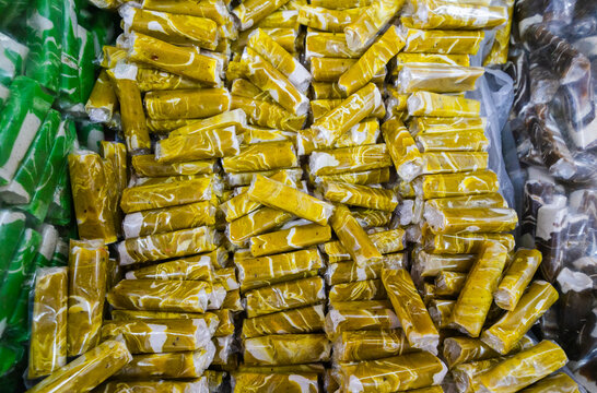 Pile of sweet green toffee called "Dodol Garut" in clear plastic wrappers. A famous Indonesian souvenir from Garut, West Java,  with a sticky texture and modern colorful look.