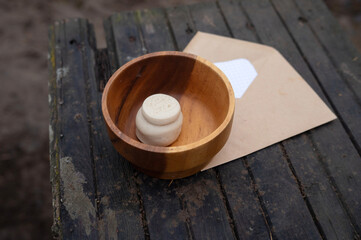 Handmade wooden bowl with unique seal on weathered wooden surface