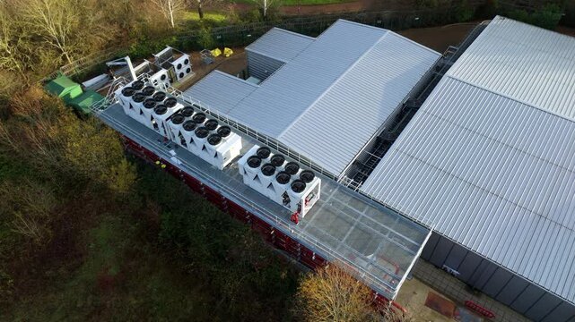 Close up aerial drone view of large scale data center, AI cloud and quantum computing cooling infrastructure. Fans and ventilation, Milton Keynes, UK