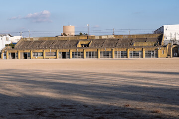 松原市民運動広場のコンクリート製メインスタンドと冬の長い影