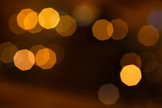 Abstract soft-focus background with warm golden octagon bokeh lights, creating a cozy and elegant atmosphere ideal for festive, holiday, luxury, or romantic designs.