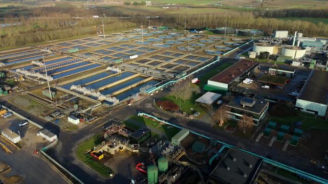 Aerial drone view of large scale Severn Trent waste water treatment plant. Sewage works Anglian water, removing waste sanitation, Milton Keynes, United Kingdom.