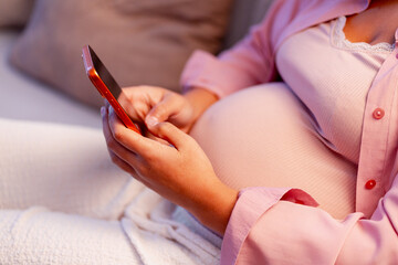 Pregnant woman using smartphone, connecting and communicating during maternity journey