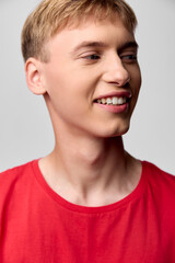 Smiling man in a redshirt, casual and cheerful, stands in studio with softlighting, a confident relaxed pose, modern lifestyle vibe, front closeup of facial expression and warm glow