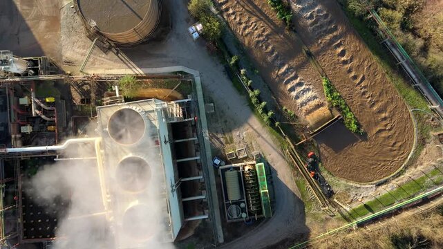 Top down aerial view of industrial cooling fans and smoke plumes with cooling water recirculation from sugar processing and production in Wissington, United Kingdom 