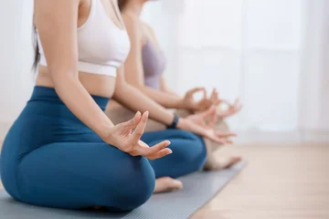 Fototapete Rund Lotusblume Close up of two women practicing meditation in lotus pose with gyan mudra for mental health at home  © Ar_TH