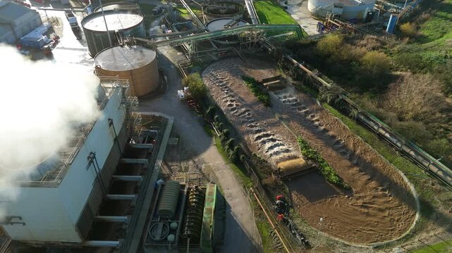 Top down aerial view of industrial cooling fans and smoke plumes with cooling water recirculation from sugar processing and production in Wissington, United Kingdom 