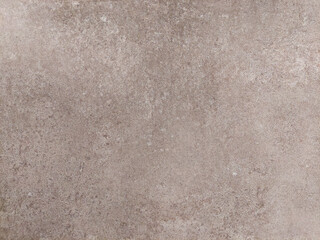 Fototapeta premium Neutral brown stone like surface or concrete wall texture suitable for graphic designs, product mockups, copy space, banners, vintage, rustic, grainy, earthy, and industrial themed backgrounds.