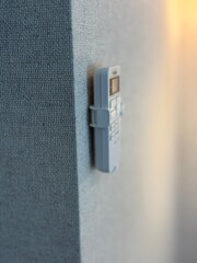 Remote control mounted on textured wall with soft light in background offering a modern aesthetic