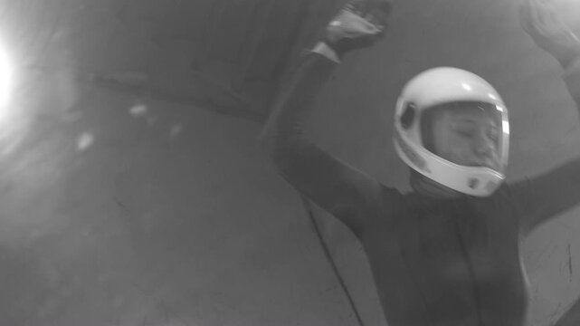 Black and white training session in a vertical wind tunnel. A woman in a jumpsuit flies upward, captured in a dynamic, powerful, and cinematic monochrome moment.
Moscow Russia 12.18.2025