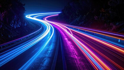 Long exposure shot of car light trails snaking through a mountain pass at night
