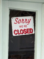 Sorry were closed sign hanging on door, signaling closure or downtime, viewed from outside
