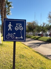 Blue traffic sign indicating pedestrian, bicycle, scooter, and vehicle lane divisions