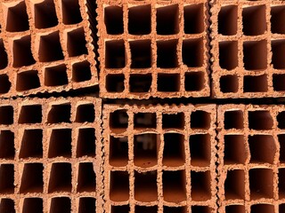 Brick wall background showcasing several stacked hollow bricks with grid-like openings