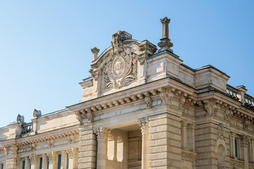 Fototapeta premium Historic stone building with classical architecture and decorative facade, shot from a low angle on a sunny day in Kutaisi, Georgia. Clear blue sky creates a calm, educational and timeless atmosphere