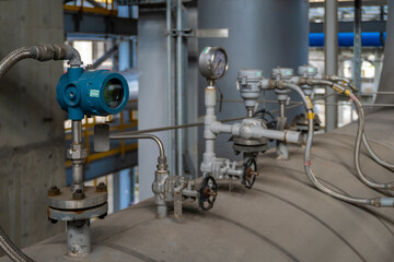 Group of valves and gauges are on a pipe. The gauges are showing the pressure of the pipe