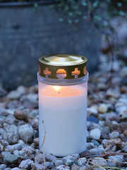 lit grave candle in a cemetery