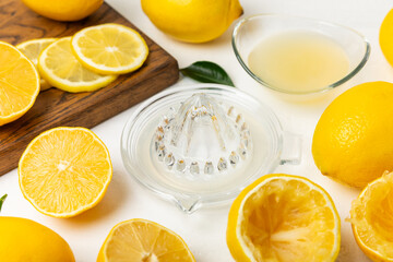 Lemon juice. Fresh lemon juice in a bowl. Ripe citrus, mint, fruit, and a juicer on the table. Vitamin C. Lemon water. Ingredient for baking or salad dressing. Space for text. Copy space.