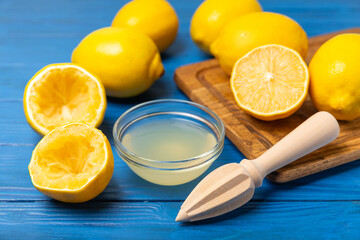Lemon juice. Fresh lemon juice in a bowl. Ripe citrus, mint, fruit, and a juicer on the table. Vitamin C. Lemon water. Ingredient for baking or salad dressing. Space for text. Copy space.