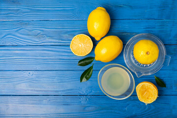 Lemon juice. Fresh lemon juice in a bowl. Ripe citrus, mint, fruit, and a juicer on the table. Vitamin C. Lemon water. Ingredient for baking or salad dressing. Space for text. Copy space.
