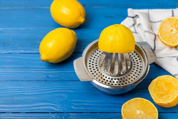 Lemon juice. Fresh lemon juice in a bowl. Ripe citrus, mint, fruit, and a juicer on the table. Vitamin C. Lemon water. Ingredient for baking or salad dressing. Space for text. Copy space.
