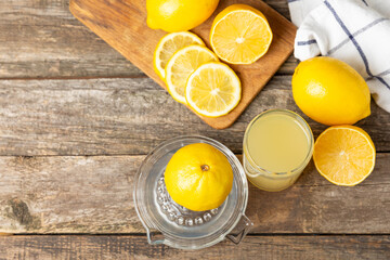 Lemon juice. Fresh lemon juice in a bowl. Ripe citrus, mint, fruit, and a juicer on the table. Vitamin C. Lemon water. Ingredient for baking or salad dressing. Space for text. Copy space.