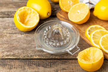 Lemon juice. Fresh lemon juice in a bowl. Ripe citrus, mint, fruit, and a juicer on the table. Vitamin C. Lemon water. Ingredient for baking or salad dressing. Space for text. Copy space.