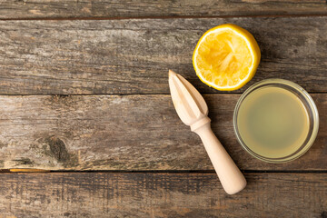 Lemon juice. Fresh lemon juice in a bowl. Ripe citrus, mint, fruit, and a juicer on the table. Vitamin C. Lemon water. Ingredient for baking or salad dressing. Space for text. Copy space.