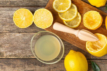 Lemon juice. Fresh lemon juice in a bowl. Ripe citrus, mint, fruit, and a juicer on the table. Vitamin C. Lemon water. Ingredient for baking or salad dressing. Space for text. Copy space.