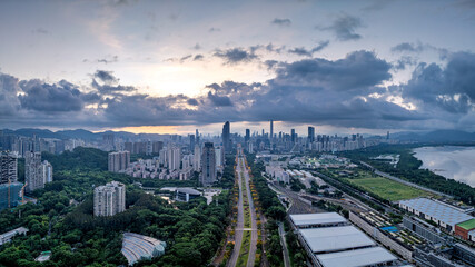 Aerial view of city skyline and green park at dusk in Shenzhen, China.