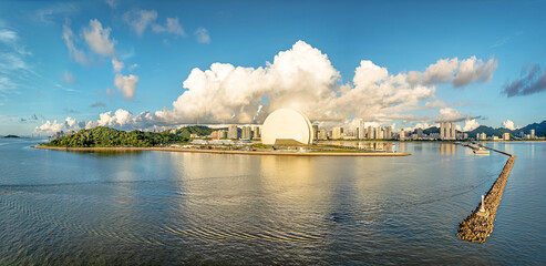 Aerial view of island and city skyline under dramatic clouds in Zhuhai, China.