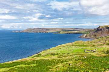 Rugged coastline and blue sea on Isle of Skye Scotland