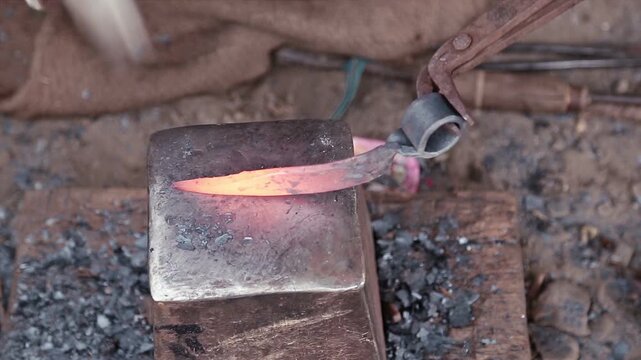 Farming iron tools heat over glowing embers in a small Uttarakhand village blacksmith shop, showing rural livelihood, poverty, manual labor, and traditional mountain craftsmanship.