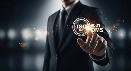 A businessman points to a glowing ISO 9001 QMS quality management system icon.