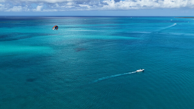 Parasailing At Providenciales In Turks And Caicos. Idyllic Beach. Nature Landscape. Aquatic Sport. Parasailing In Turks And Caicos. Aquatic Sport Landscape.