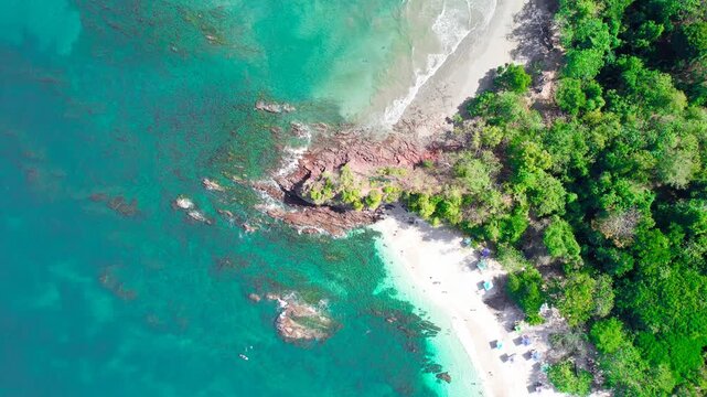 Aerial View of Tropical Beach with Turquoise Water, Rocky Shore and Lush Green Forest