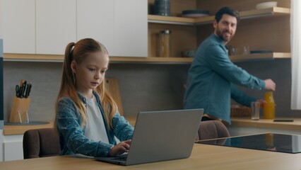 Caucasian happy family morning at home man father smiling in kitchen pouring fresh vitamin healthy juice in glasses preparing drink for girl kid child daughter studying using laptop media chat online