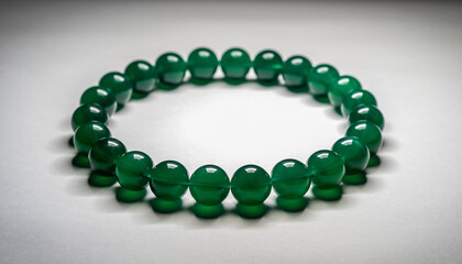 Green Beaded Bracelet Resting On Gray Surface.