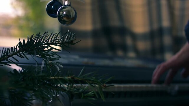 Christmas tree with woman playing Christmas carols on piano organ in background