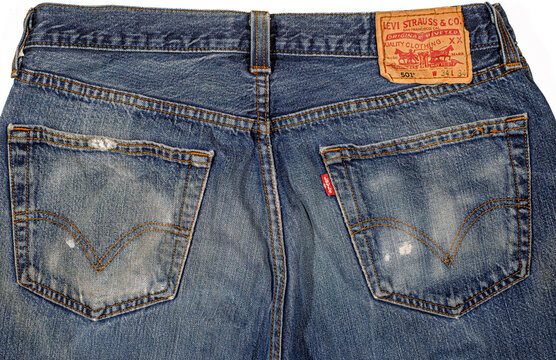 Italy, February 10, 2022. A close-up back view of a pair of classic blue Levi's 501 jeans, showing the leather patch, red tab, and distressed denim texture.