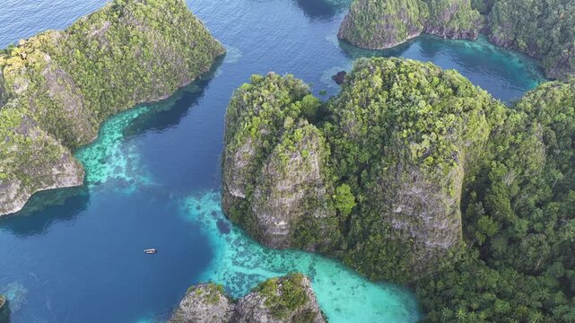 Rock islands, composed of ancient, uplifted reefs, rise from the seascape in Misool, Indonesia. This region harbors spectacular marine biodiversity and is a popular diving destination.
