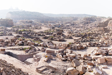 industrial mining site with extracted stone slabs in Aravalli mountain range at day