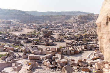 stone mining industry scene with exposed rock formations in Aravalli mountain range at day