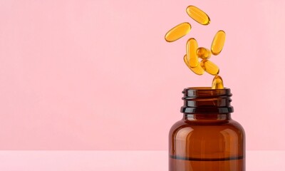 Yellow Capsules Pouring from a Brown Bottle on a Pink Background