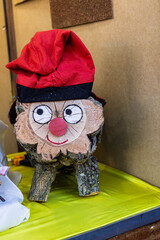 A close-up of a wooden Caga Tio log with a painted face and red barretina hat, a classic Catalan Christmas tradition.