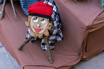 A close-up of a wooden Caga Tio log with a painted face and red barretina hat, a classic Catalan Christmas tradition.