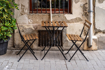 Empty Wooden Bistro Table and Chairs on Sidewalk