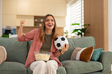 Woman cheering watching football game at home
