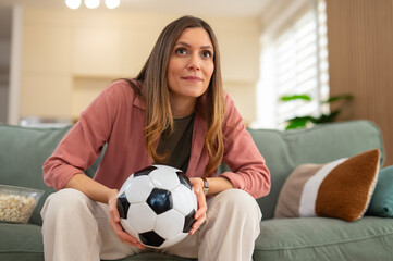 Woman watching football match at home