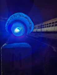 Railroad traffic light with blue signal at the night station